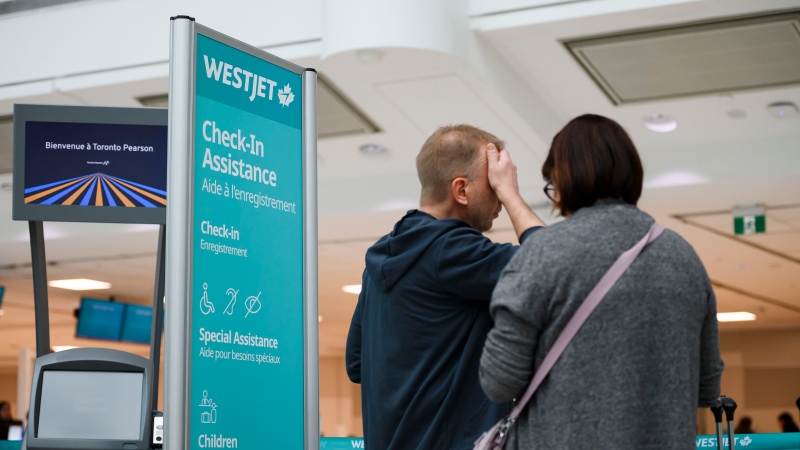 Passengers are seen in the WestJet check-in area at Pearson International Airport, in Toronto, Saturday, June 29, 2024. (THE CANADIAN PRESS/Christopher Katsarov)