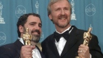 FILE - James Cameron, right, and Jon Landau hold the Oscars for Best Picture for the film "Titanic" at the 70th annual Academy Awards at the Shrine Auditorium in Los Angeles, March 23, 1998. (AP Photo/Reed Saxon, File)